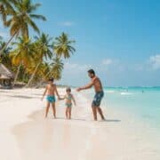 Beautiful beach in Punta Cana with a family enjoying the sun, representing real estate investment opportunities
